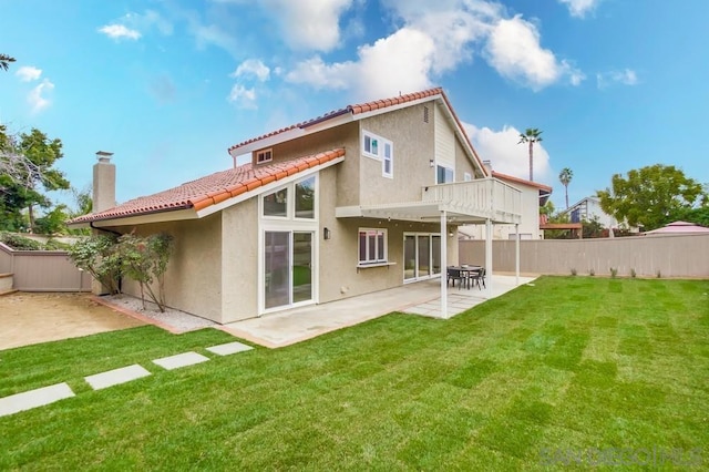 rear view of property featuring a lawn and a patio