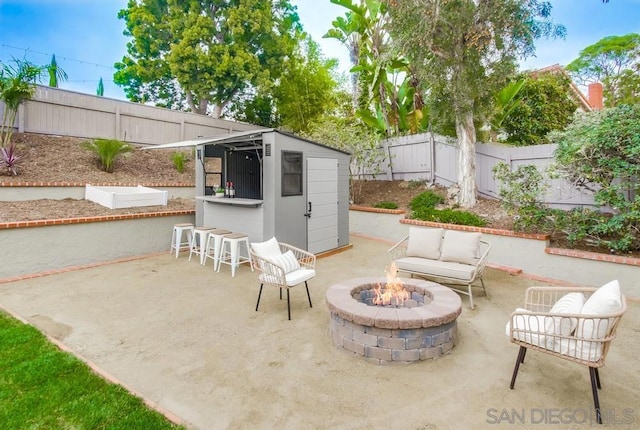 view of patio / terrace featuring a storage unit, an outdoor bar, and a fire pit