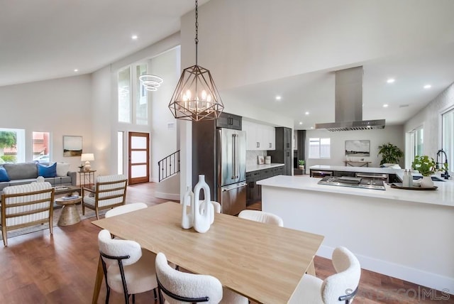 dining room featuring a high ceiling, wood-type flooring, and a chandelier