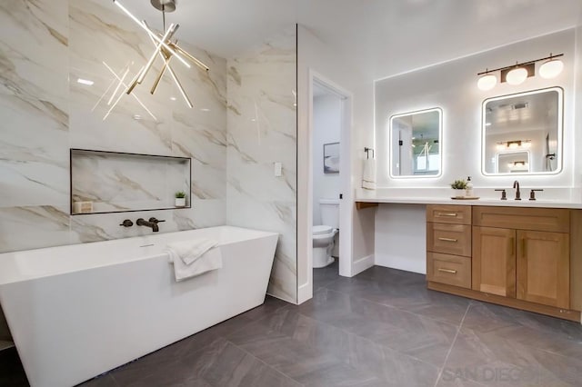 bathroom with vanity, a tub, and toilet