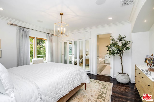 bedroom with an inviting chandelier, connected bathroom, dark wood-type flooring, and ornamental molding