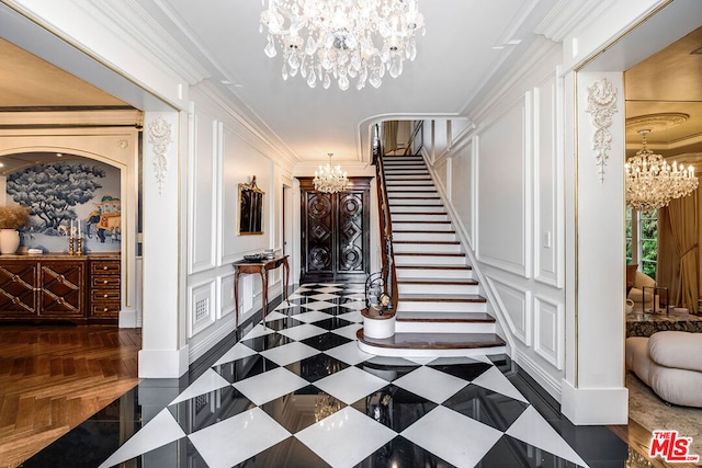 interior space featuring an inviting chandelier, dark parquet floors, and ornamental molding