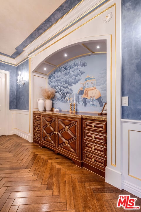 interior space with ornamental molding and dark parquet flooring