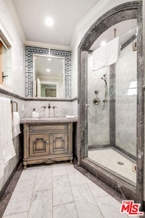 bathroom with vanity, crown molding, tile walls, and tiled shower