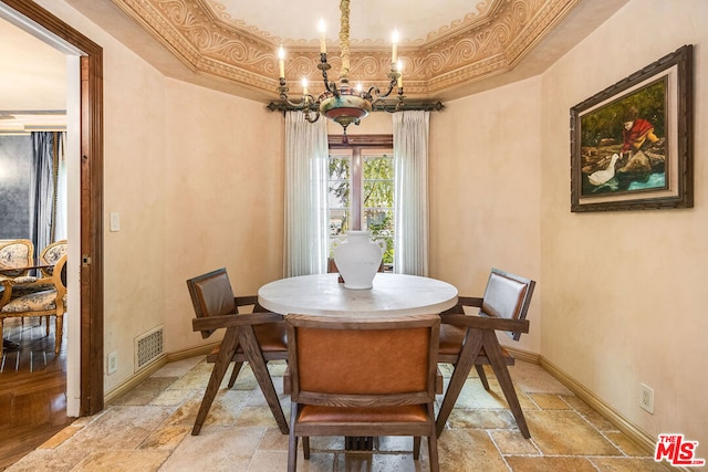 dining area featuring an inviting chandelier and a tray ceiling