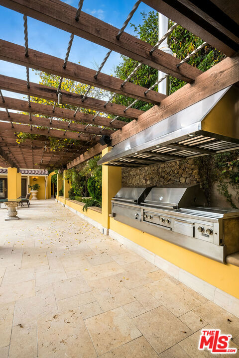 view of patio with an outdoor kitchen, grilling area, and a pergola