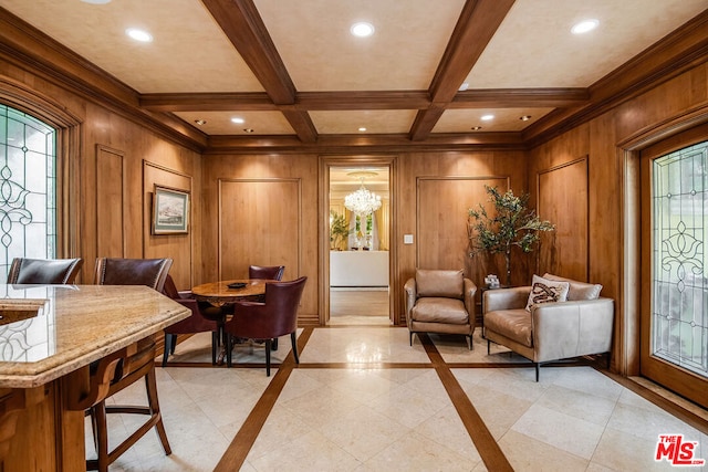 sitting room featuring beamed ceiling, coffered ceiling, an inviting chandelier, and a wealth of natural light