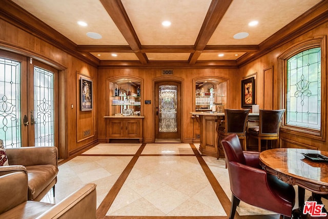 living area with french doors, coffered ceiling, wood walls, ornamental molding, and beamed ceiling