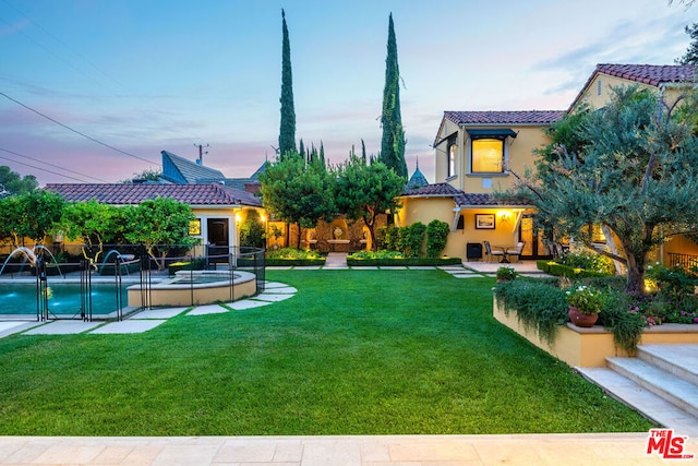 yard at dusk featuring a patio