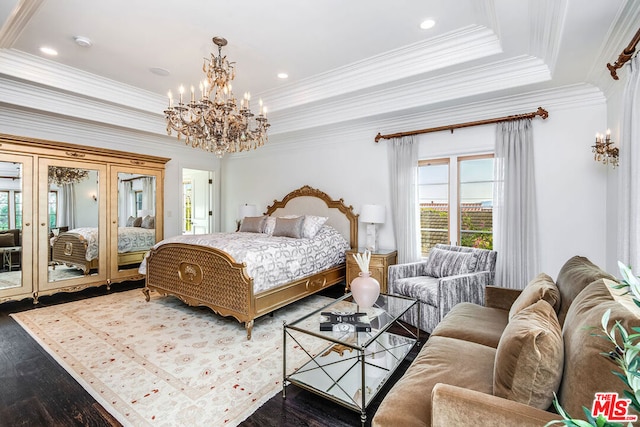 bedroom featuring hardwood / wood-style flooring, a raised ceiling, access to exterior, and an inviting chandelier