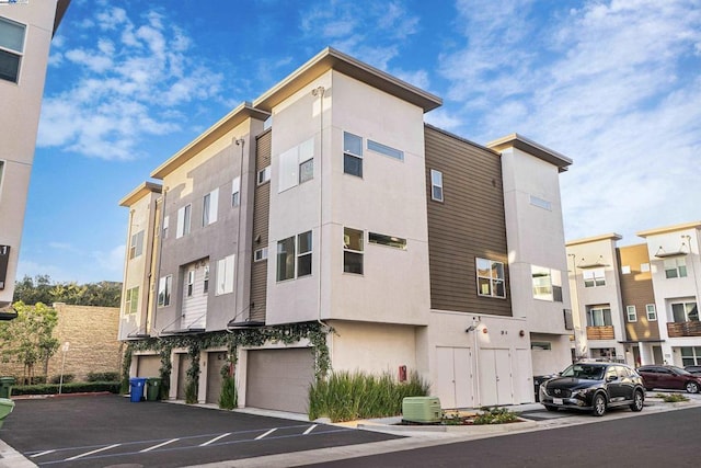 view of building exterior with a garage and cooling unit