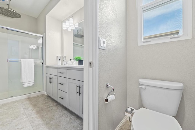 bathroom with vanity, tile patterned flooring, a shower with shower door, and toilet