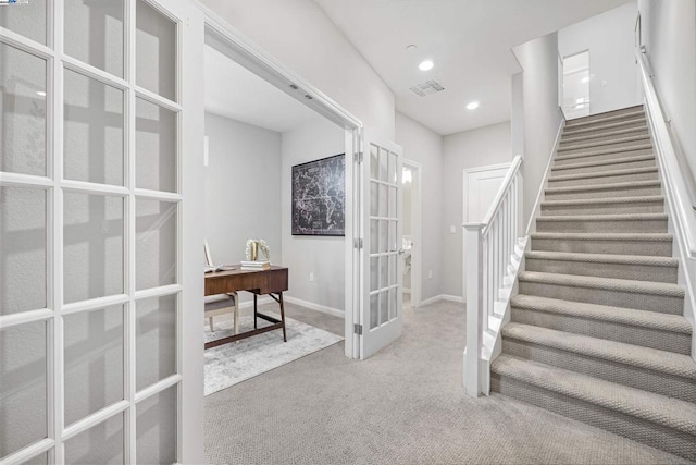 stairway featuring french doors and carpet flooring