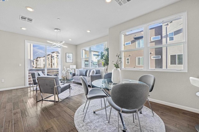 dining area featuring dark hardwood / wood-style flooring and a notable chandelier