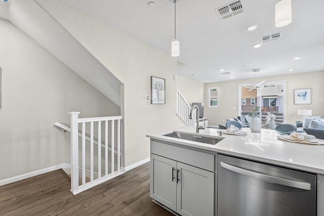 kitchen featuring decorative light fixtures, sink, gray cabinetry, stainless steel dishwasher, and dark wood-type flooring