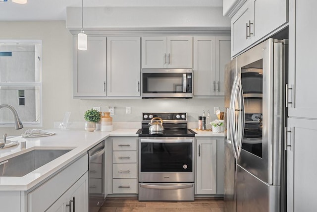 kitchen featuring pendant lighting, stainless steel appliances, dark hardwood / wood-style floors, and sink