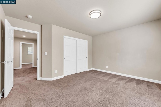 unfurnished bedroom featuring carpet floors and a closet