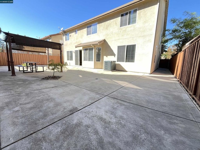 rear view of house with central AC unit and a patio area