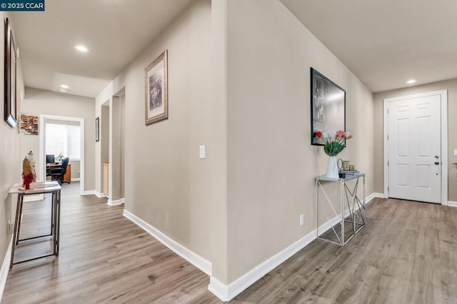 corridor with light hardwood / wood-style floors