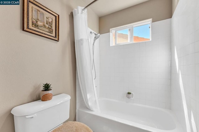 bathroom with shower / bathtub combination with curtain and toilet