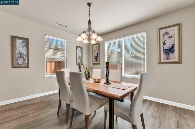 dining room featuring wood-type flooring and a chandelier