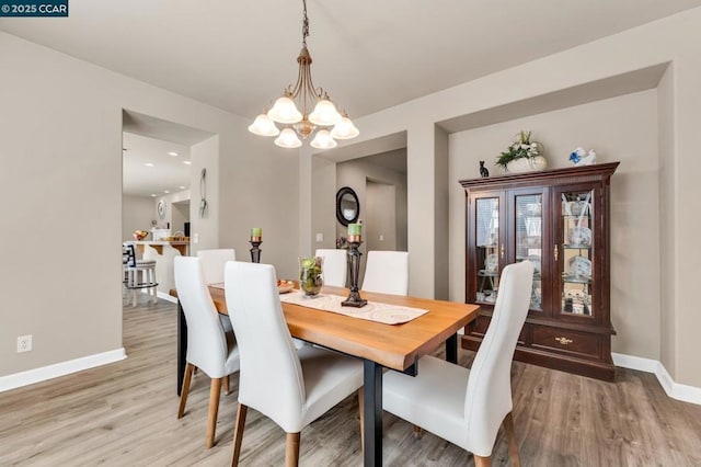 dining room with hardwood / wood-style floors and a chandelier