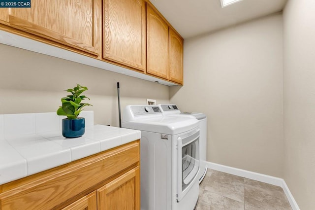 washroom with washing machine and dryer and cabinets