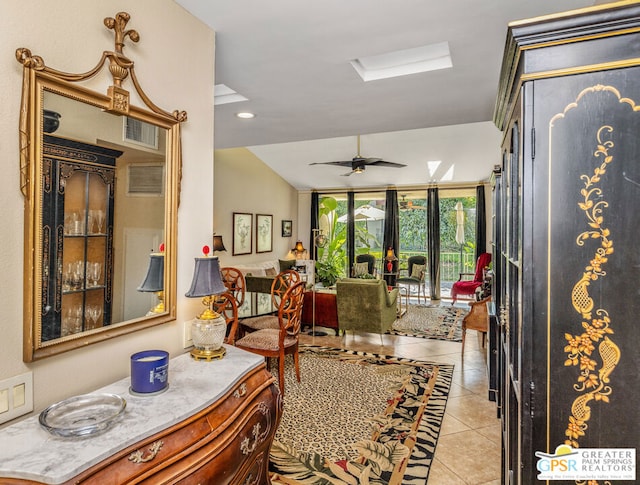 interior space with ceiling fan and lofted ceiling with skylight