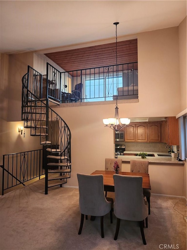 carpeted dining area featuring sink and a high ceiling