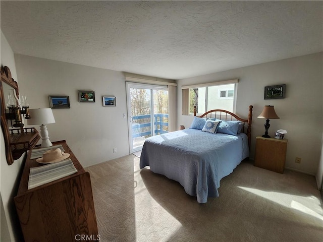 bedroom featuring light colored carpet, access to exterior, and a textured ceiling