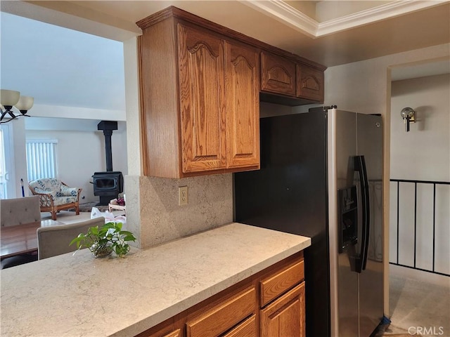 kitchen featuring backsplash, stainless steel fridge, and a wood stove