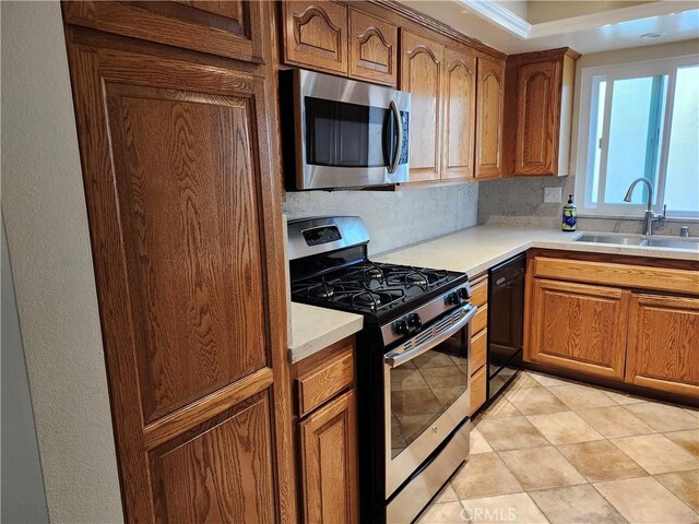 kitchen featuring sink, decorative backsplash, light tile patterned floors, and appliances with stainless steel finishes