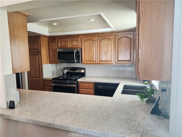 kitchen featuring light stone counters, sink, tasteful backsplash, and appliances with stainless steel finishes