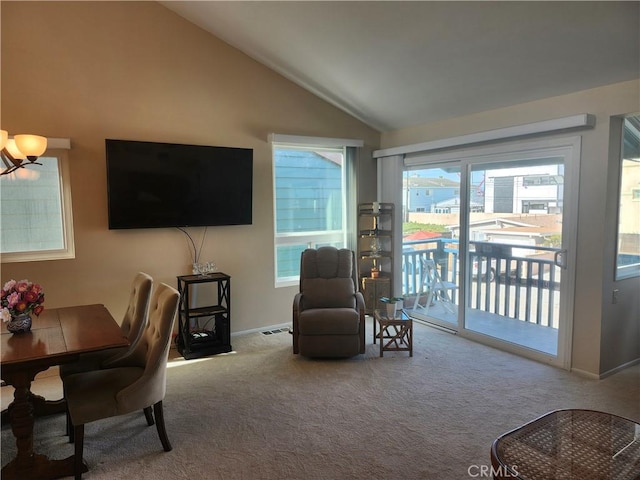 living room featuring a chandelier, vaulted ceiling, and light carpet