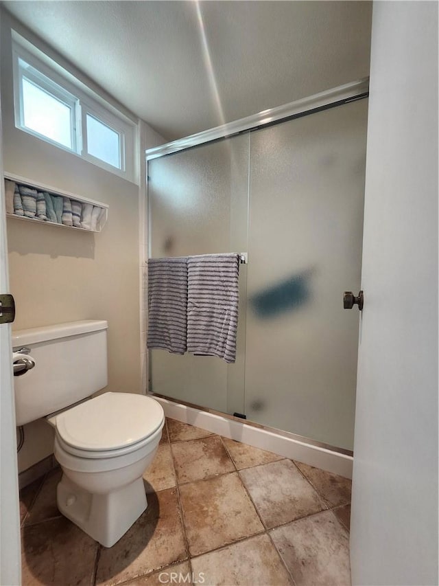 bathroom featuring walk in shower and toilet