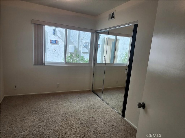 unfurnished bedroom featuring carpet floors and a closet