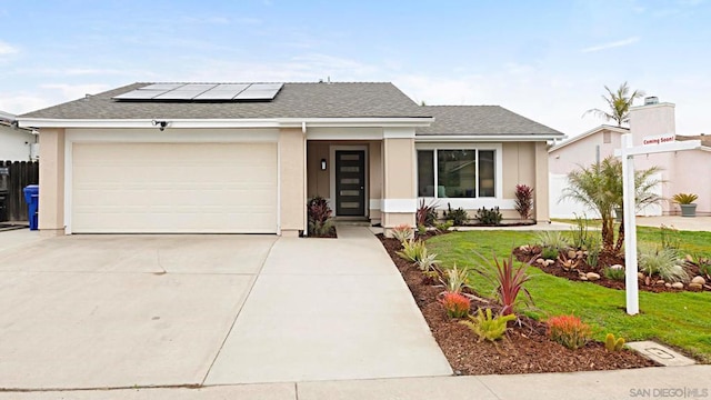 view of front of house with a garage, a front lawn, and solar panels