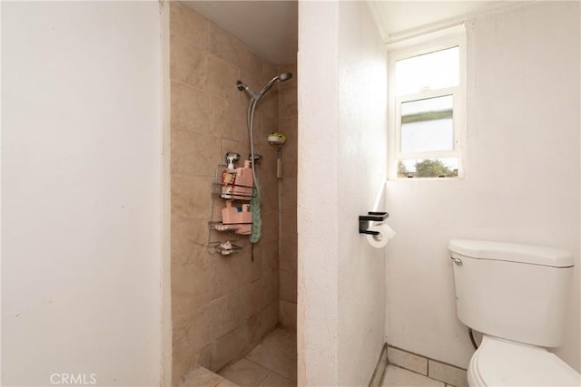 bathroom with toilet and a tile shower