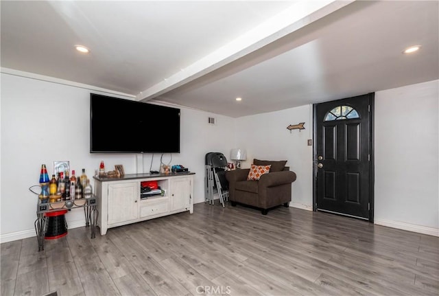 living room featuring beamed ceiling and light wood-type flooring