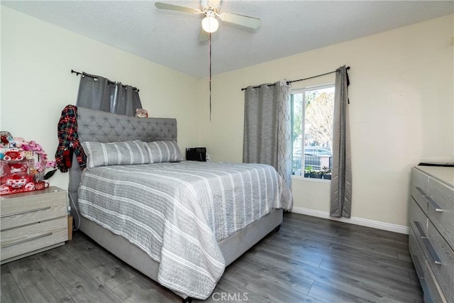 bedroom with ceiling fan, dark hardwood / wood-style floors, and a textured ceiling