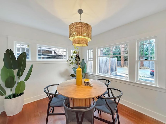 dining space featuring hardwood / wood-style flooring, plenty of natural light, and a notable chandelier