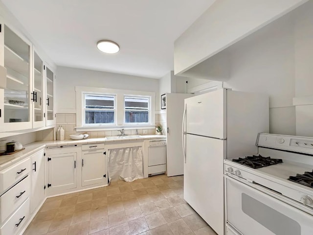 kitchen with white cabinetry, sink, white appliances, and tasteful backsplash