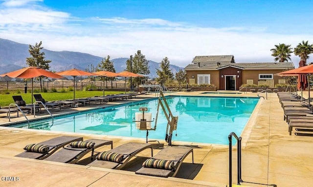 view of swimming pool with a mountain view and a patio area