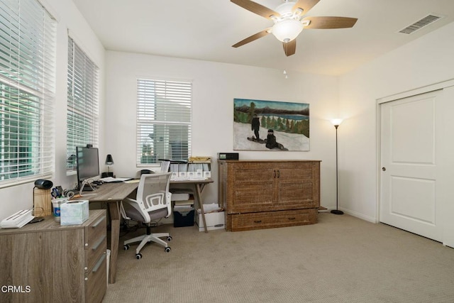 home office featuring ceiling fan, a healthy amount of sunlight, and light carpet