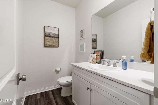 bathroom featuring vanity, hardwood / wood-style floors, and toilet