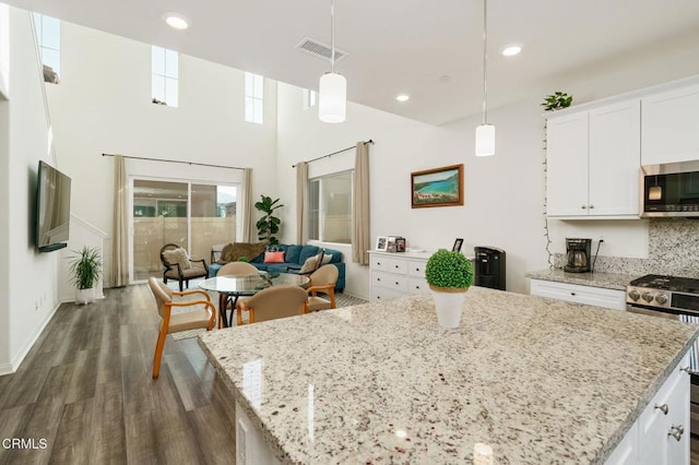 kitchen featuring appliances with stainless steel finishes, white cabinetry, and hanging light fixtures