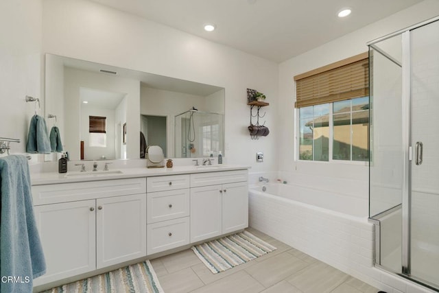 bathroom with a sink, visible vents, a shower stall, a bath, and double vanity