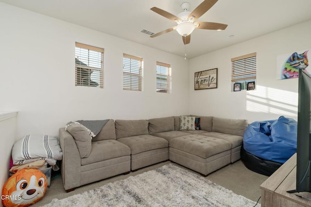 living room with light colored carpet, ceiling fan, and visible vents