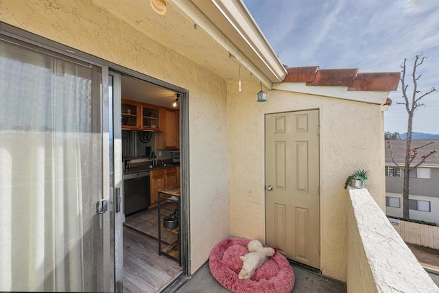 view of exterior entry featuring sink and a balcony