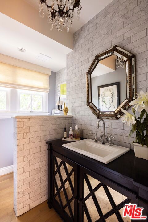 bathroom with vanity, hardwood / wood-style flooring, and tasteful backsplash